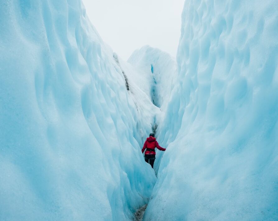 female walking through huge glacier crevasses at Falljokull