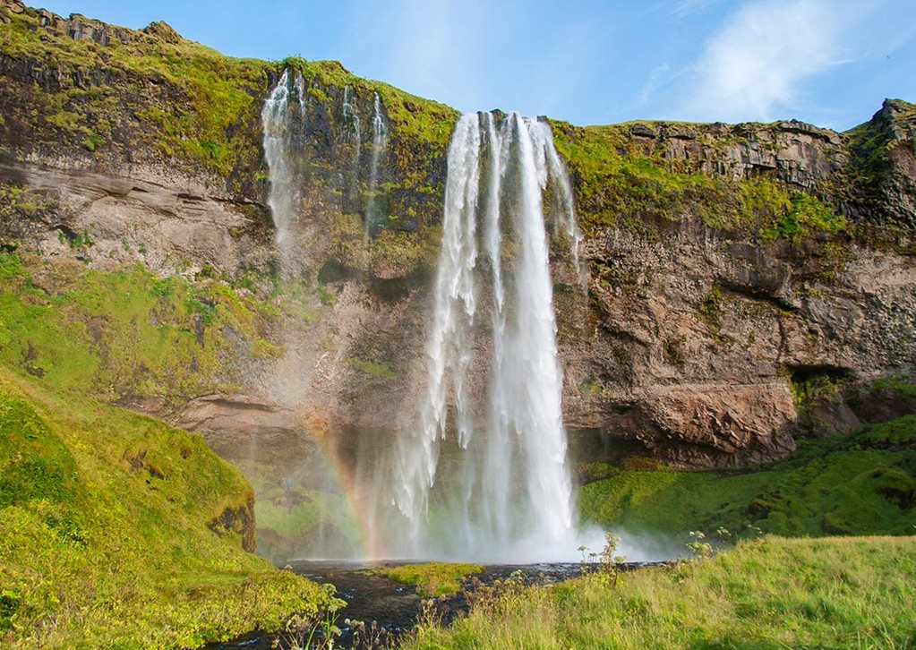 Seljalandsfoss waterfall with rainbow in the spray, South Iceland