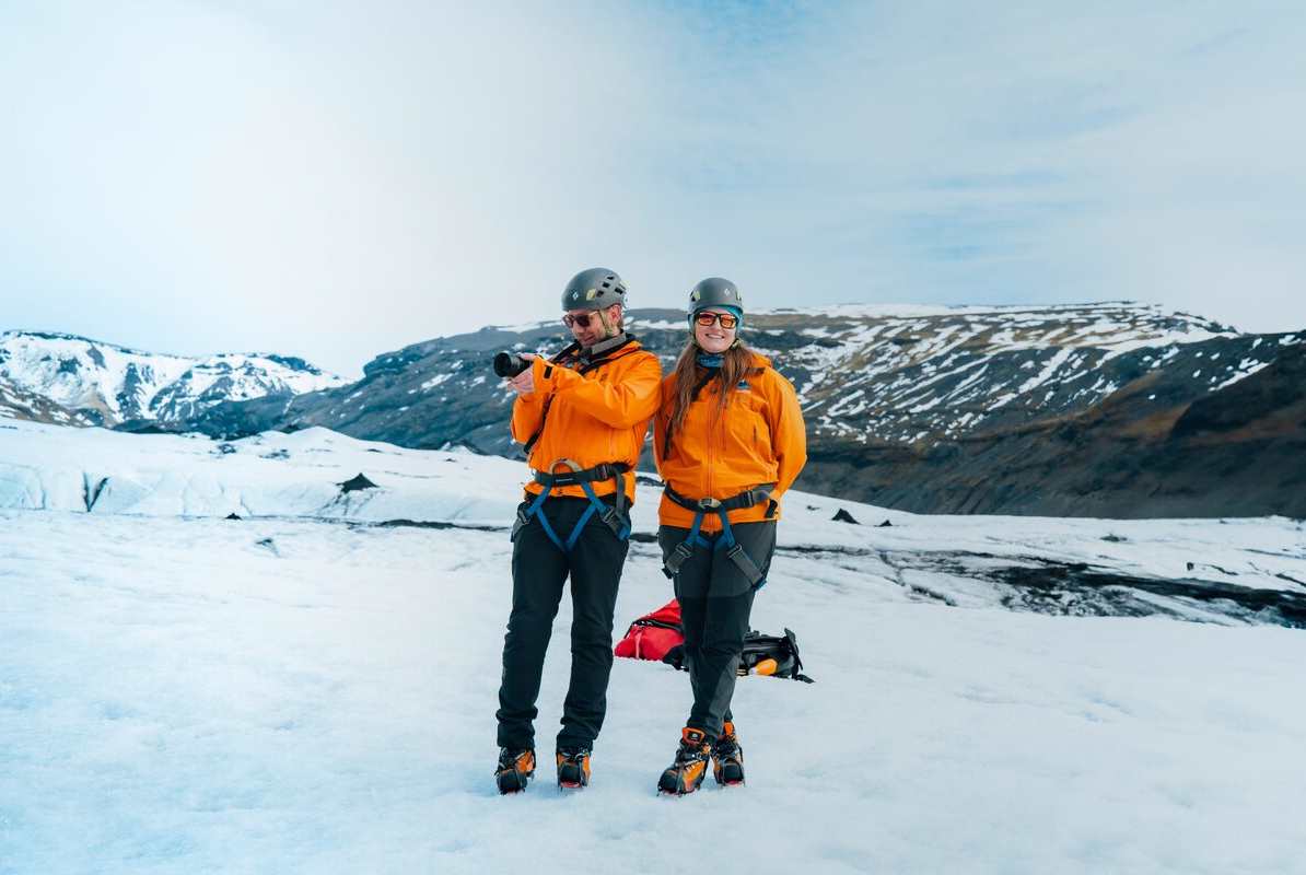 Couple posing for photo on Solheimajokull glacier.