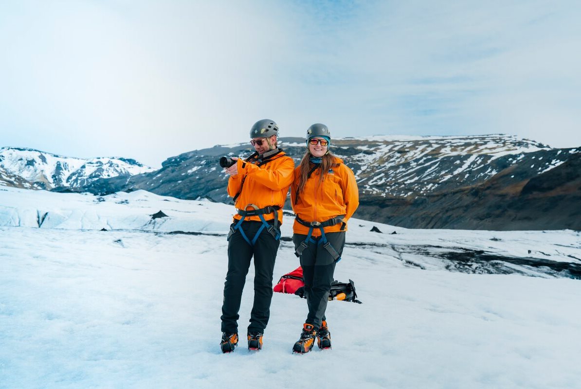 Couple posing for photo on Solheimajokull glacier.