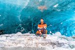 Man inside natural ice cave in Iceland