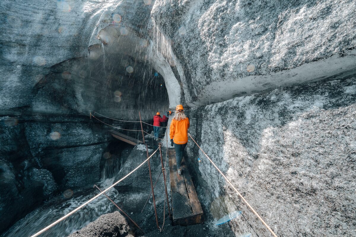 Tour group hiking on dark volcanic ash ice route