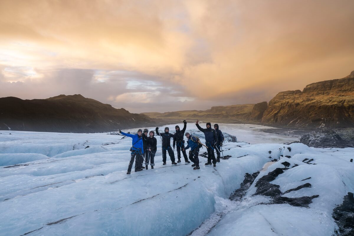group posing for a photo on solheimajokull glacier in iceland