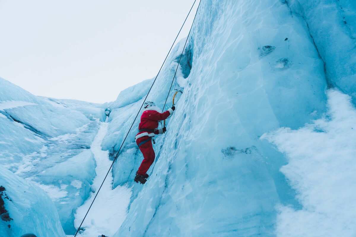 santa claus climbing an ice wall in iceland