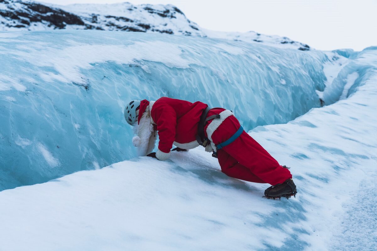 santa looking into ice crevasses in iceland