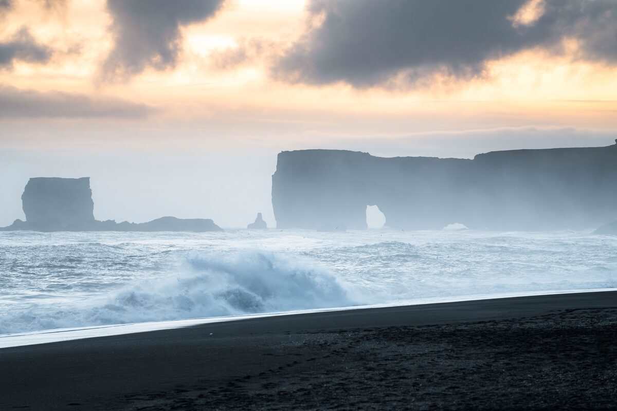crashing waves on a black sand beach during winter in iceland