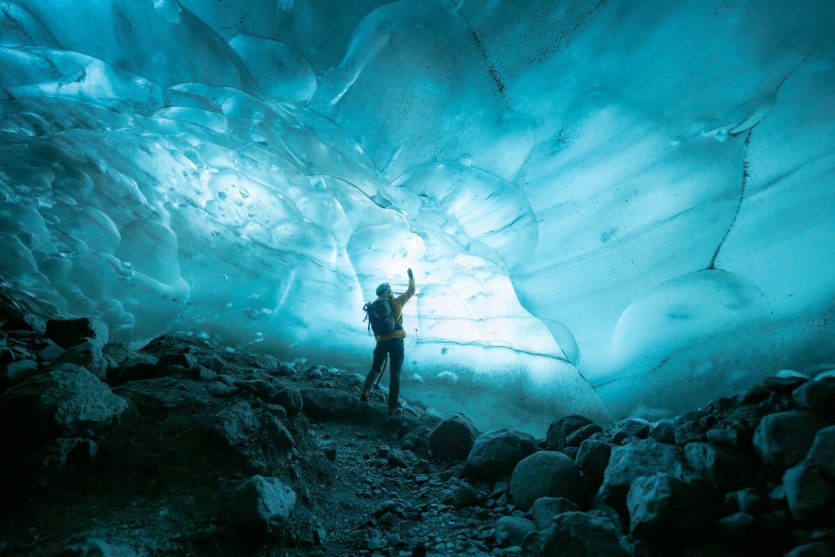 person touching the walls of crystal ice cave in iceland