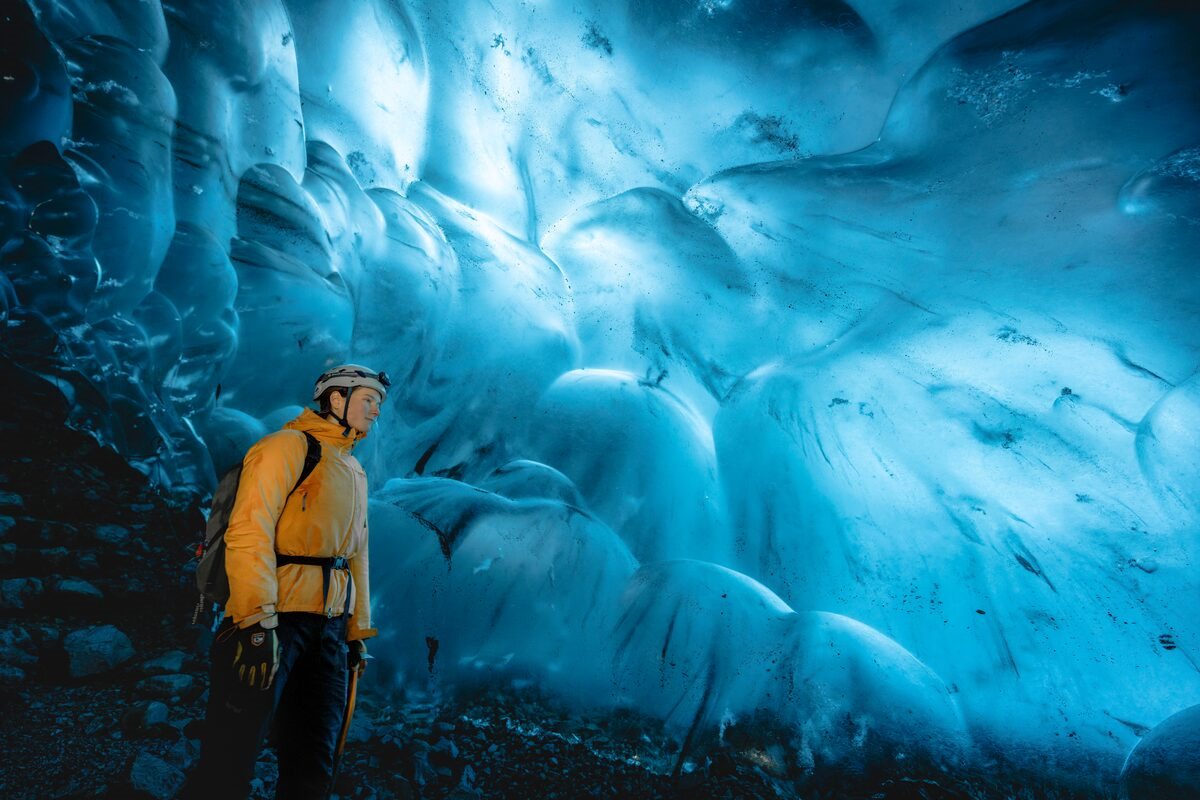 crystal ice cave walls and woman near them in iceland