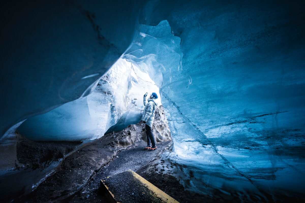 tourist taking pictures inside katla ice cave in iceland