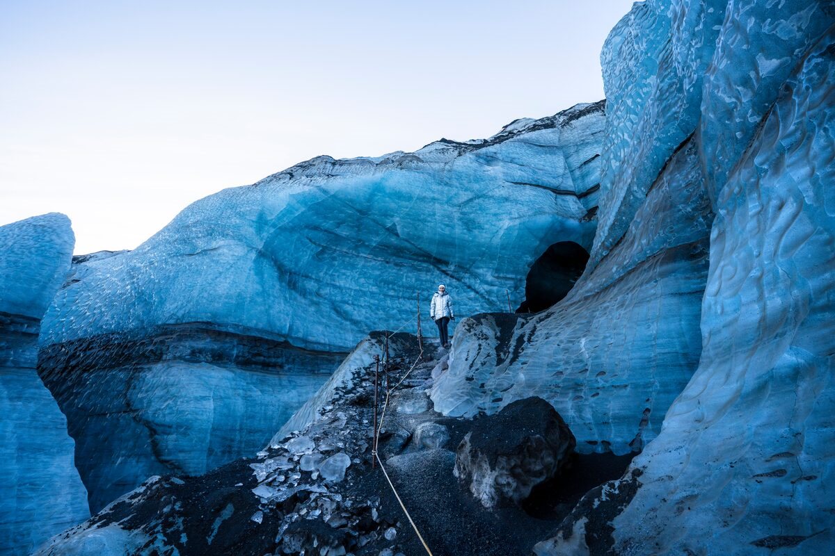 woman walking down a path from katla ice cave in iceland