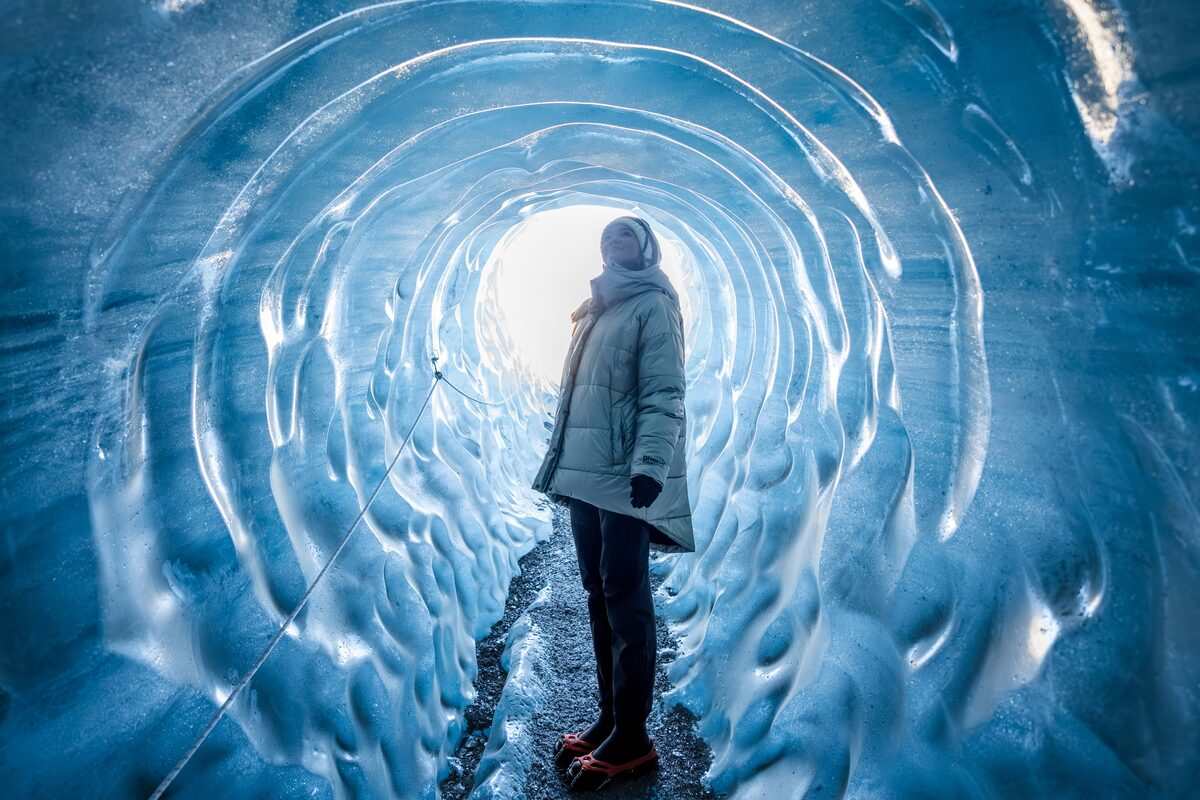 woman mesmerized by the ice walls of katla ice cave in iceland