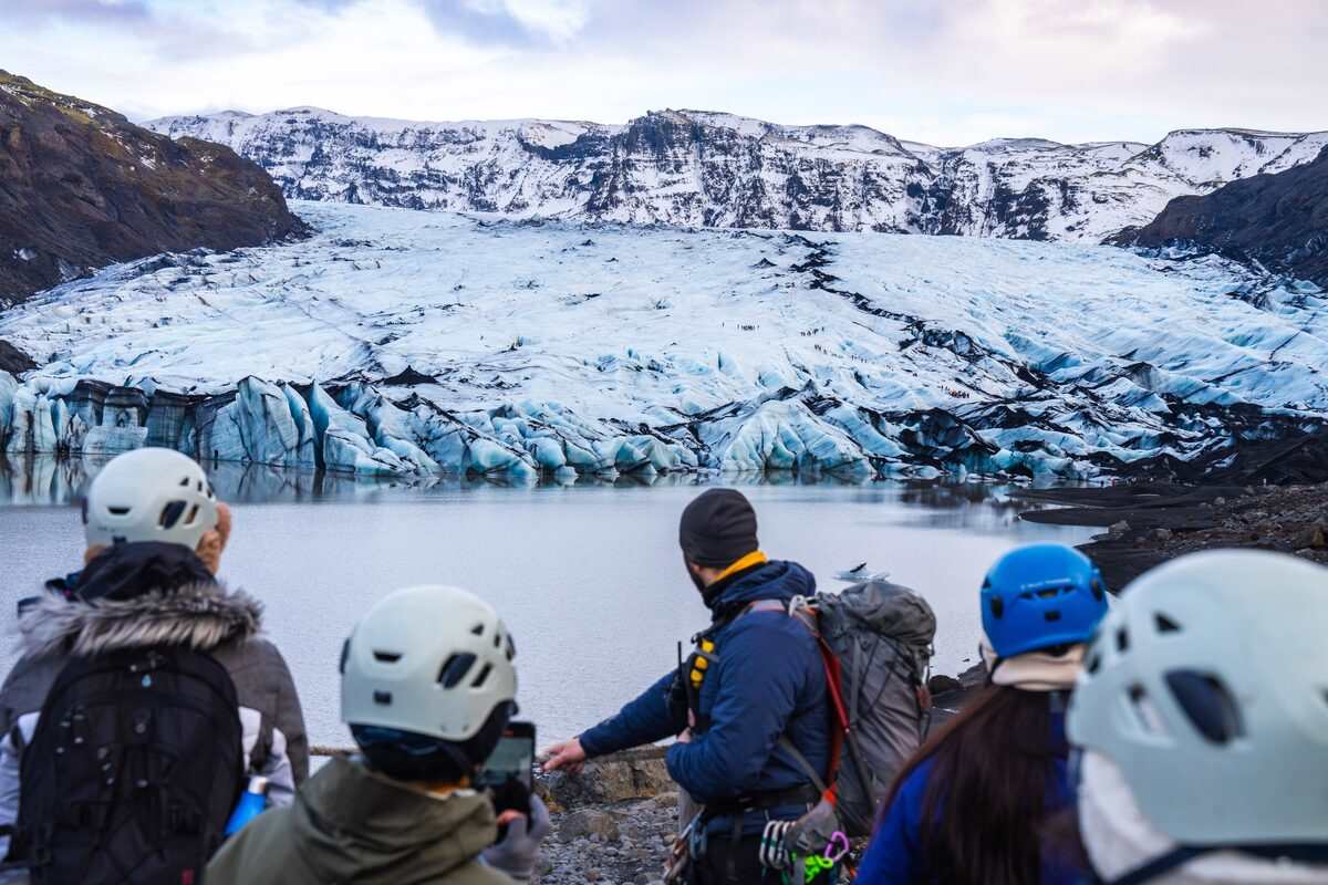 group of people looking at a glacier in iceland