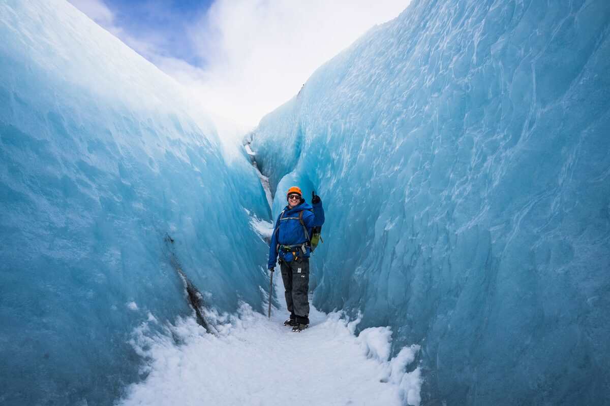 Man Smilling Standing Between Glacier Crevasses in Iceland